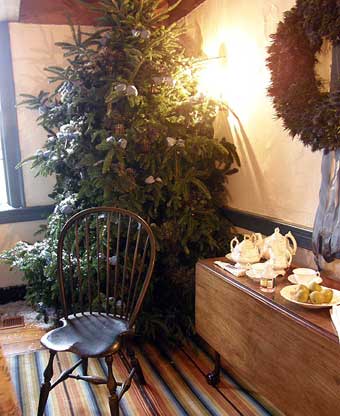 Vanderveer House - A decorated Christmas tree behind a windsor chair and a claw foot drop leaf table.
