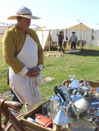 Frederick Market Fair - Tinsmith Scott Baylor from Mifflinburg, Pennsylvania traveling throughout Fort Frederick just as a colonial tinsmith would in colonial times, pulling his tin wares in a cart.
